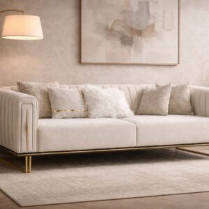 Cream velvet sofa with channel tufting and gold accents styled in a bright modern interior.