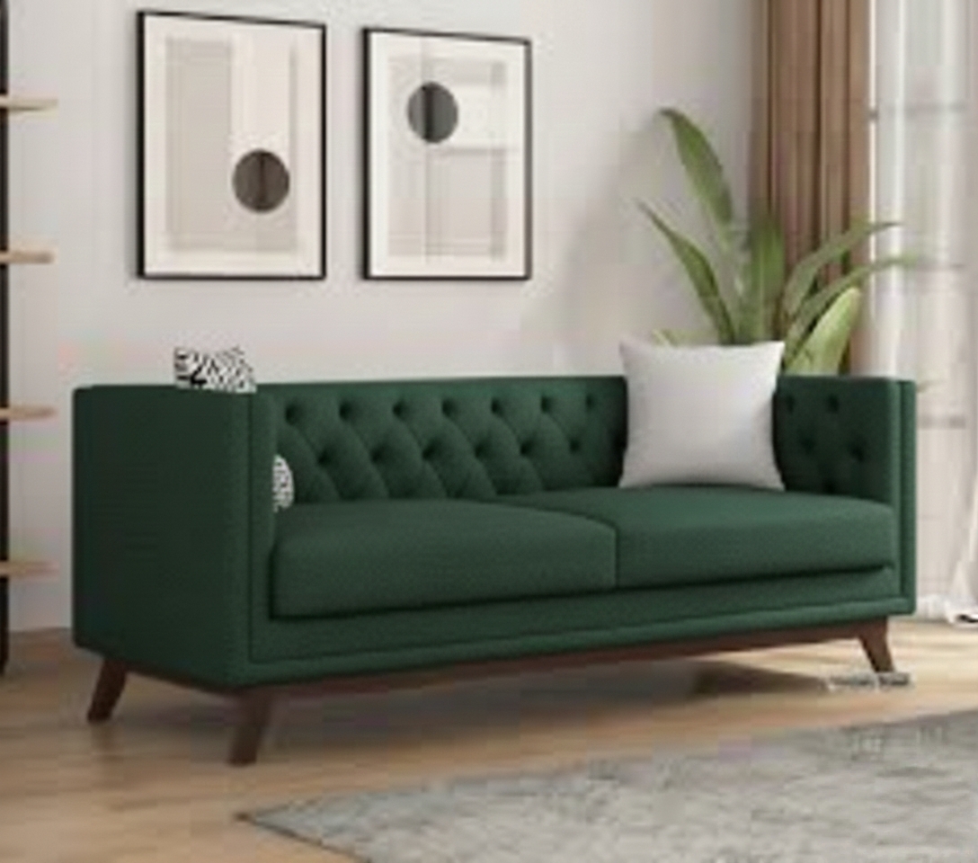 Emerald green tufted sofa in a modern minimalist living room with wall art and indoor plant décor.