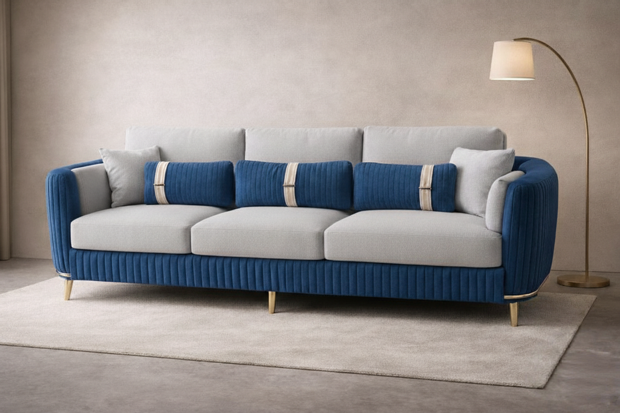 Royal blue and beige sofa with teal accent cushions and gold legs on a glossy white floor