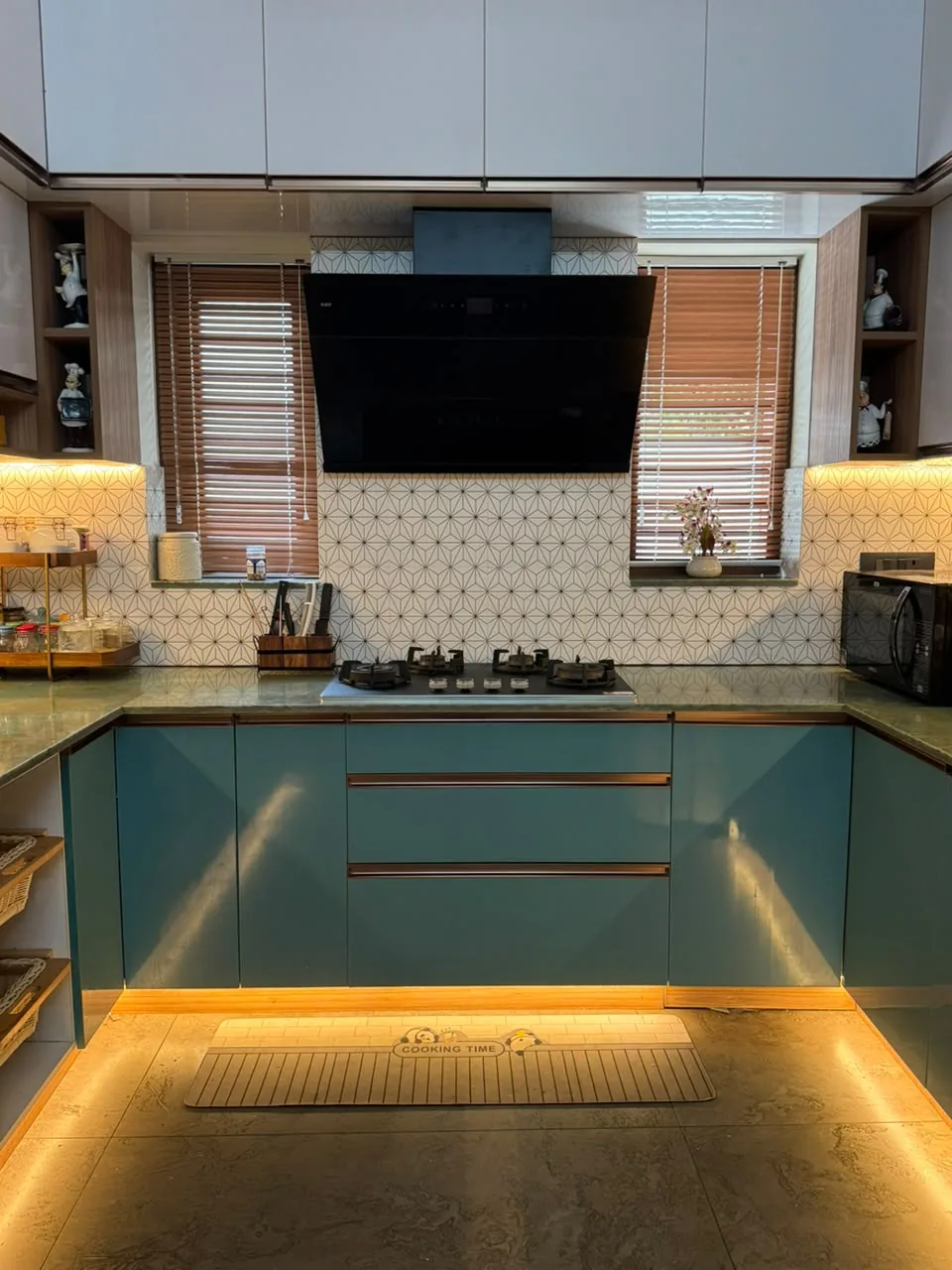Teal modular kitchen with green stone counter and geometric patterned tile splashback
