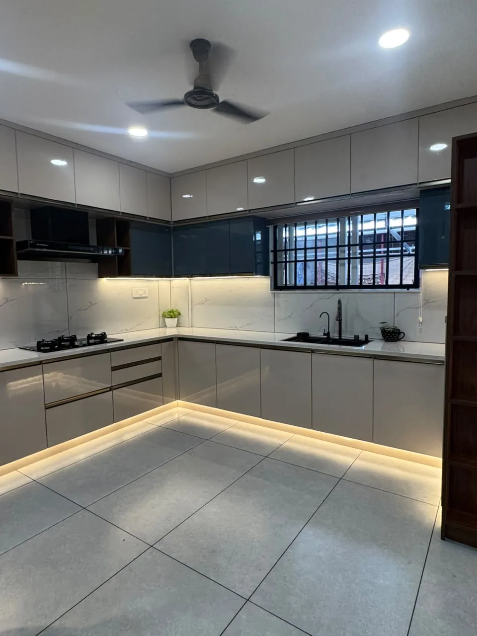 U-shaped modular kitchen in greige and navy with under-cabinet and plinth LED lighting